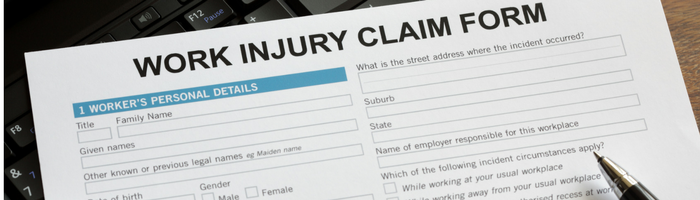 A work injury claim form on a piece of paper with a pen.